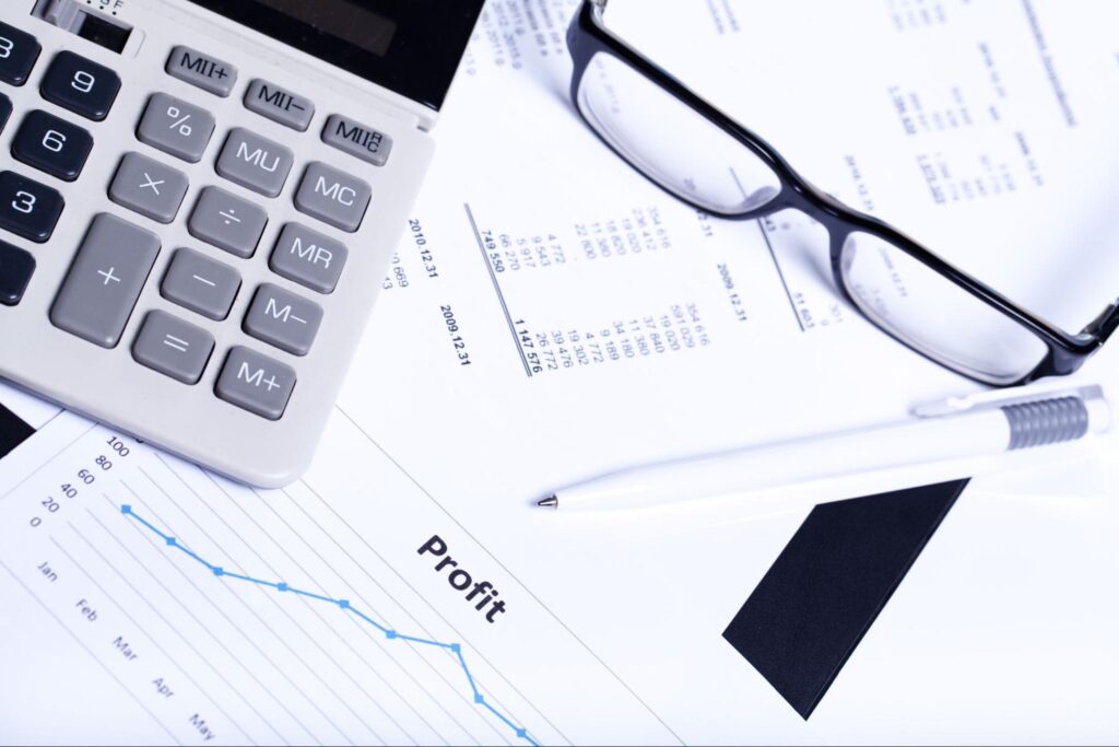 Office desk with a calculator, documents, and performance graphs