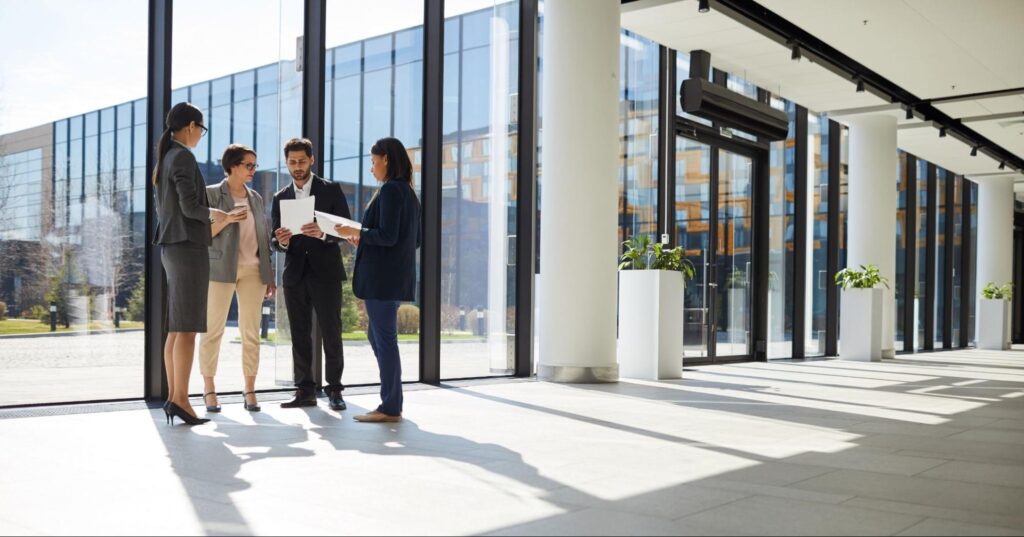 Group of professionals in a commercial office space, emphasizing the significance of lease abstracts in property management.