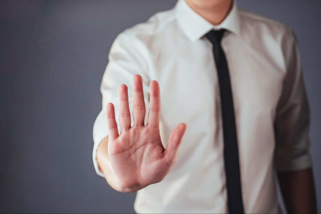 Corporate professional signaling a warning, symbolizing the red flags to avoid when choosing a commercial real estate agency in Tampa.