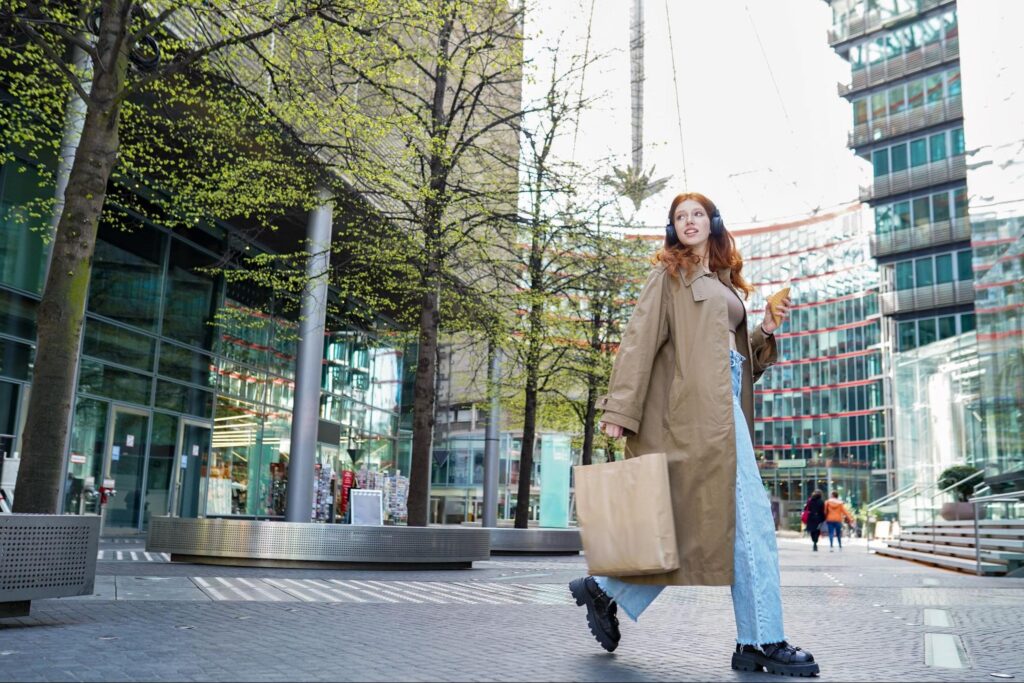 Casually dressed woman walking in an urban business area with skyscrapers