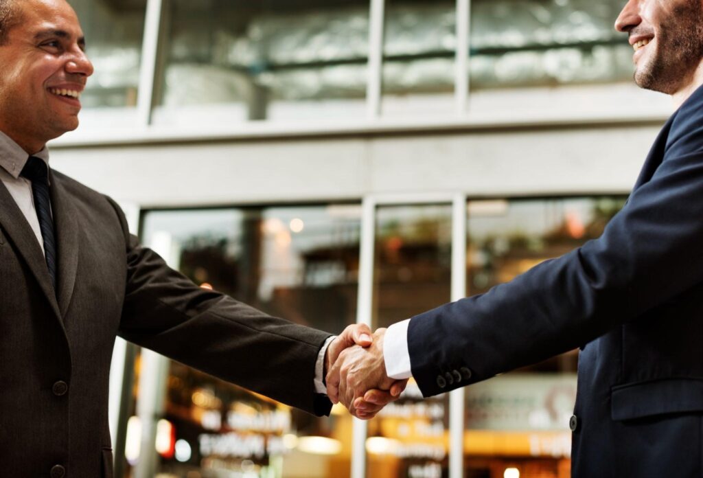 Two business professionals shaking hands in a formal meeting.