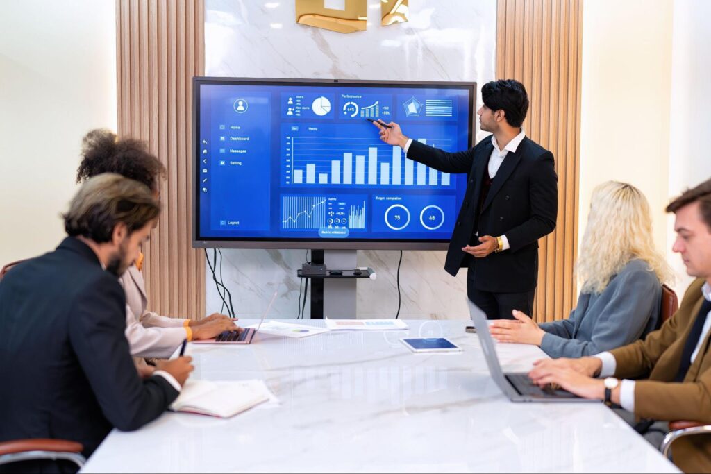 Business presentation taking place in a conference room with people attentively listening.