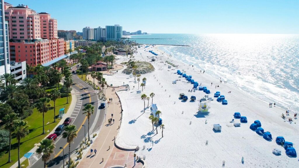 Tourists strolling along Clearwater Beach with nearby shops and cafes