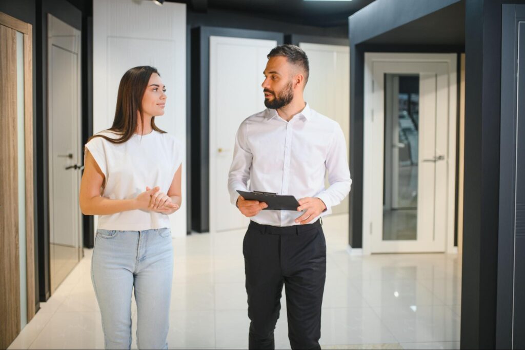 Property manager showing a tenant around a commercial retail space inside a mixed-use building.